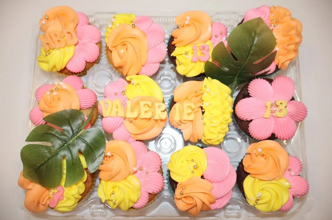 Pink, orange and yellow cupcakes spelling a name