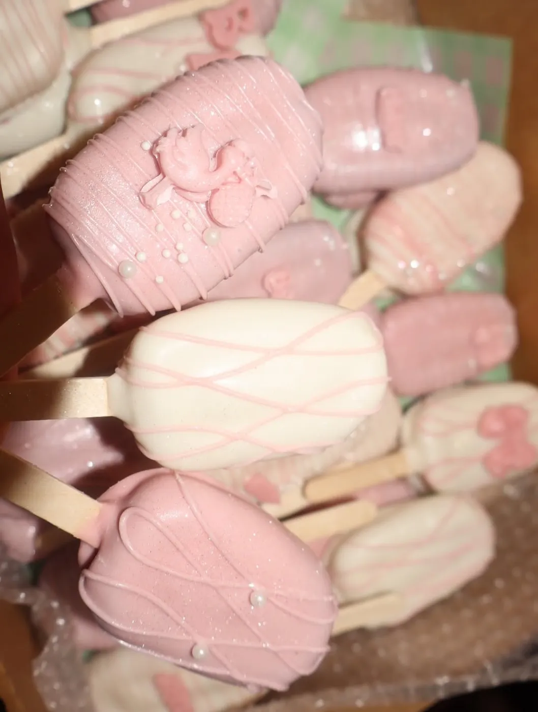 Pink and white cakesicles decorated with bows