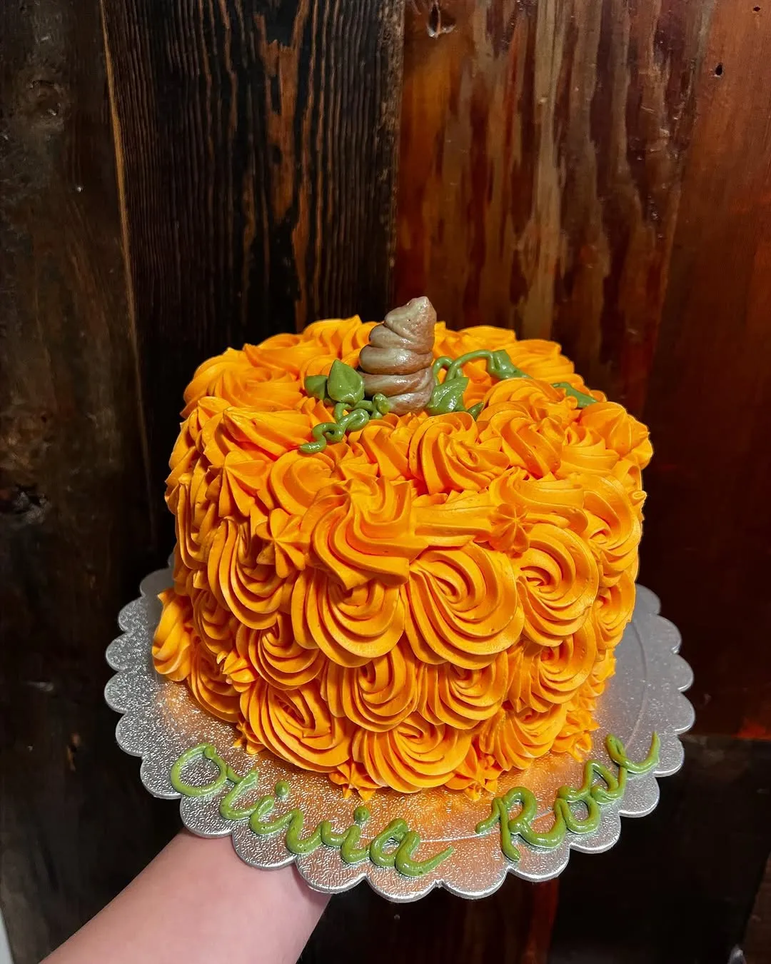 Orange rosette pumpkin cake on a gold board