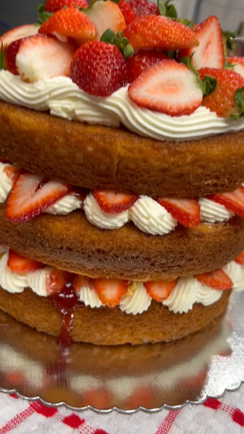 Layered sponge cake with whipped cream and fresh strawberries