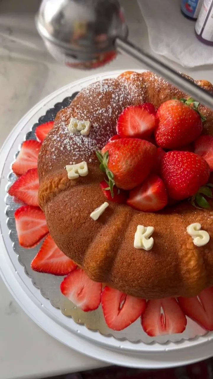 Bundt cake dusted with sugar and topped with strawberries